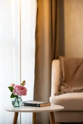 a vase of flowers on a table next to a couch at Spirit apartment in Burgas City