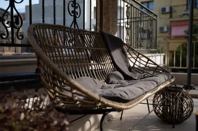 a wicker chair sitting on a balcony at Spirit apartment in Burgas City