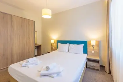 a bedroom with a large white bed with towels on it at All-inclusive Holiday Apartments in Tarsis Hotel & Aquapark in Sunny Beach