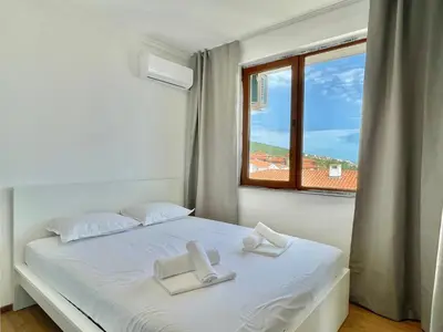 a bedroom with a white bed with a window at Tryavna Beach - Private apartment - BSR - 4 in Sveti Vlas