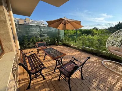 a patio with a table and chairs and an umbrella at Sea apartment in Burgas City