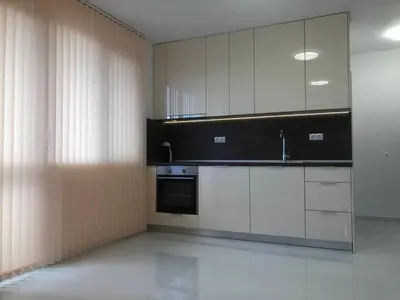 a kitchen with white cabinets and a black appliance at Blue Magenta 1 in Sozopol