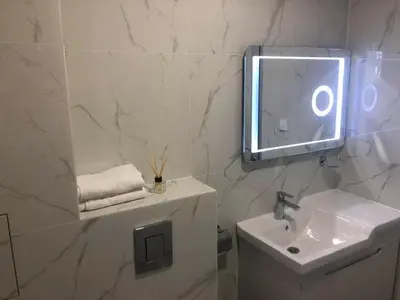 a white bathroom with a sink and a mirror at Blue Magenta 1 in Sozopol
