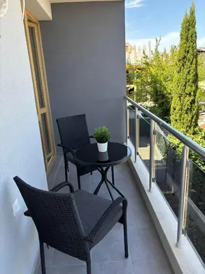 a balcony with two chairs and a table with a plant at Blue Magenta 2 in Sozopol