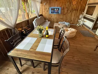 a dining table and chairs in a living room at Каравана Мир in Chernomorets