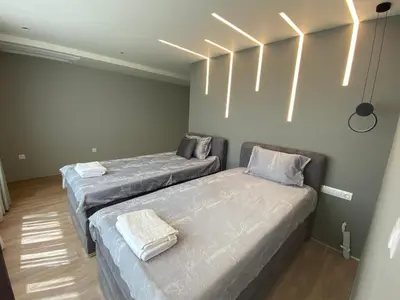 two beds in a room with lights on the wall at Luxurious house Sarafovo beach in Burgas City