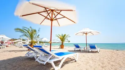 a group of chairs and umbrellas on a beach at Luxurious house Sarafovo beach in Burgas City