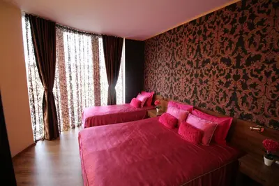 two pink beds in a room with pink sheets at Семеен Хотел Идън in Sveti Vlas