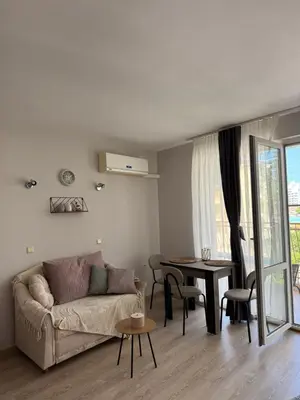 a living room with a couch and a table at Студиа Осака in Sunny Beach