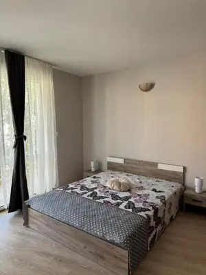 a dog laying on a bed in a bedroom at Студиа Осака in Sunny Beach