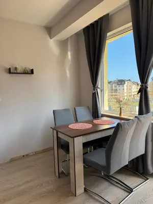a dining room with a table and chairs and a window at Студиа Осака in Sunny Beach