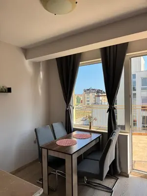 a dining room with a table and chairs and a window at Студиа Осака in Sunny Beach