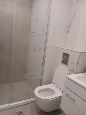 a white bathroom with a toilet and a shower at Chantrer in Burgas City