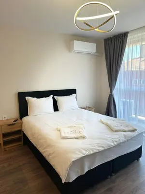 a bedroom with a large bed with a chandelier at Chantrer in Burgas City