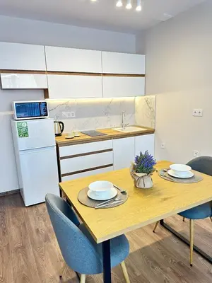 a kitchen with a wooden table with two plates on it at Chantrer in Burgas City