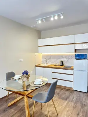 a kitchen with a glass table and two chairs at Chantrer in Burgas City