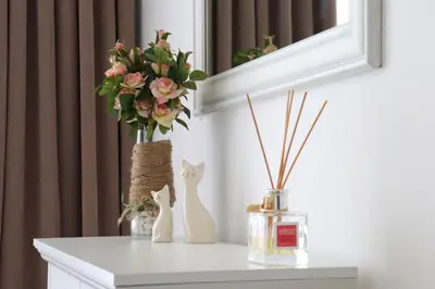 a white table with a vase of flowers and a mirror at Stylish Paradiso Apartment 206 in Nesebar