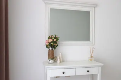 a white cabinet with a vase of flowers on it at Stylish Paradiso Apartment 206 in Nesebar