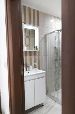 a bathroom with a white sink and a shower at Stylish Paradiso Apartment 206 in Nesebar