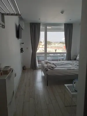 a bedroom with a bed and a large window at Paradiso Aparthotel, Studio 106 in Nesebar