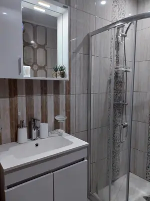 a bathroom with a shower and a white sink at Paradiso Aparthotel, Studio 106 in Nesebar