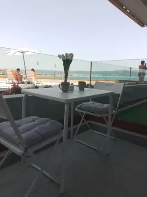 a white table and chairs with a view of the beach at Paradiso Aparthotel, Studio 106 in Nesebar