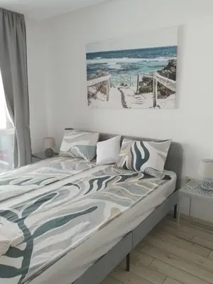 a bedroom with a bed with a picture of the beach at Paradiso Aparthotel, Studio 106 in Nesebar