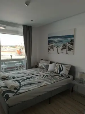 a bedroom with a bed with a view of the ocean at Paradiso Aparthotel, Studio 106 in Nesebar