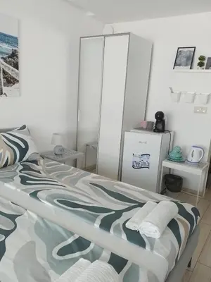 a bedroom with a bed and a refrigerator at Paradiso Aparthotel, Studio 106 in Nesebar