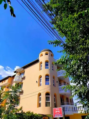 a yellow building with a balcony on top of it at Chance Sarafovo in Burgas City