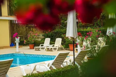 a group of chairs and an umbrella next to a pool at Студио до плажа Свети Влас in Sveti Vlas