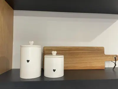 two white vases sitting on a shelf in a room at Magnoliya residence in Burgas City