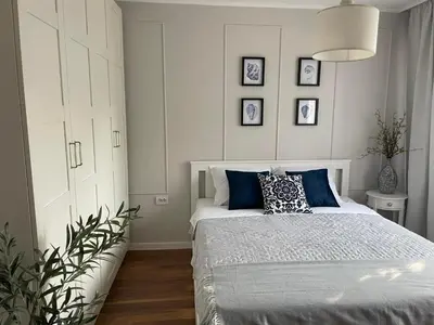 a bedroom with a bed with blue pillows on it at Magnoliya residence in Burgas City