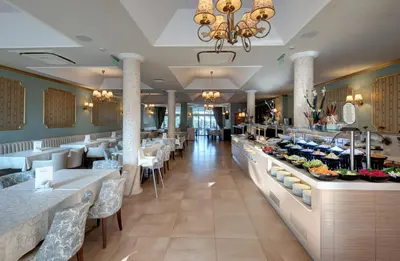 a restaurant with tables and chairs and a buffet at Hotel Miramar Sozopol in Sozopol