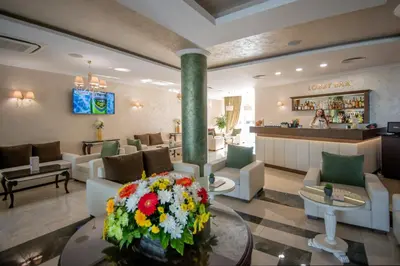 a lobby of a hotel with couches and flowers at Hotel Miramar Sozopol in Sozopol