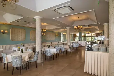 a dining room with white tables and chairs at Hotel Miramar Sozopol in Sozopol