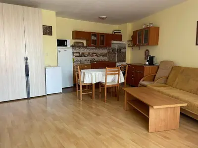 a kitchen and living room with a table and a couch at Amartmán přímo u moře - Elenite in Sveti Vlas