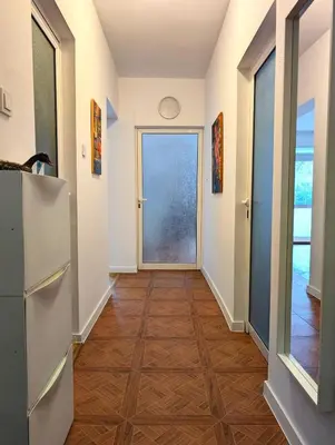 a hallway with a door leading to a hallway with wood floors at The Puzzle in Varna City