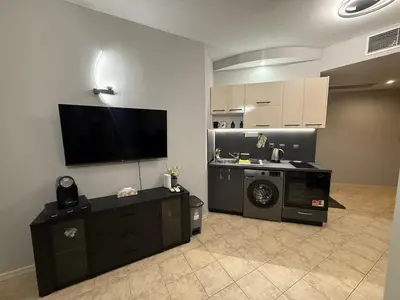 a living room with a tv and a washing machine at YS Platinum Residence in Sunny Beach