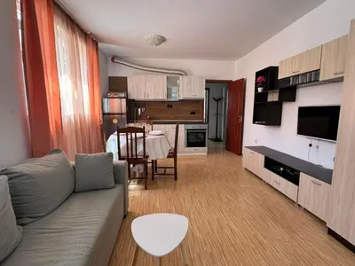 a living room with a couch and a kitchen with a table at Sunny Day 7 in Burgas City