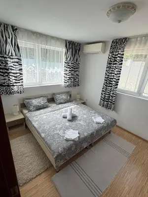 a bedroom with a bed in a room with windows at Sunny Day 7 in Burgas City