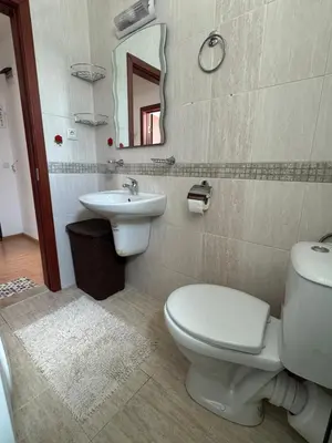 a bathroom with a toilet and a sink and a mirror at Sunny Day 7 in Burgas City