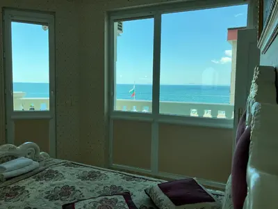 a bedroom with a bed and a view of the ocean at Апартамент в КК 