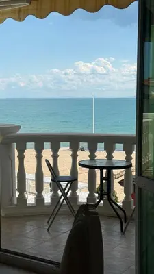 a balcony with a table and a view of the ocean at Апартамент в КК 