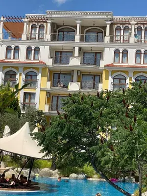 a hotel with a pool in front of a building at Schöne Ferienwohnung im Harmony Suites Monte Carlo in Sunny Beach