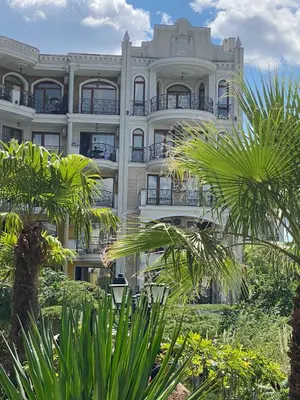 a large white building with palm trees in front of it at Schöne Ferienwohnung im Harmony Suites Monte Carlo in Sunny Beach