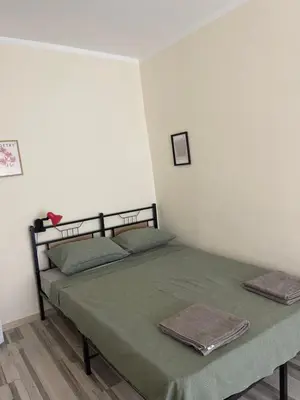 a bedroom with a bed with a green bedspread at Mila 6 in Burgas City