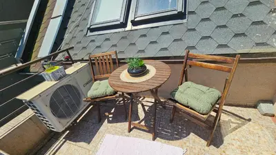 a table and two chairs with a plant on a patio at Уютно студио до центъра на Бургас in Burgas City