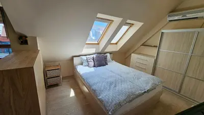 a small bedroom with a bed and two windows at Уютно студио до центъра на Бургас in Burgas City