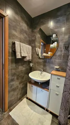 a bathroom with a sink and a mirror at Уютно студио до центъра на Бургас in Burgas City
